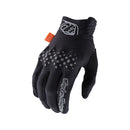 The Troy Lee Designs GAMBIT GLOVE BLACK features a checkered pattern, white branding, logo patches, an orange wrist tag, visible ventilation holes, and three-layer softshell construction for comfort.