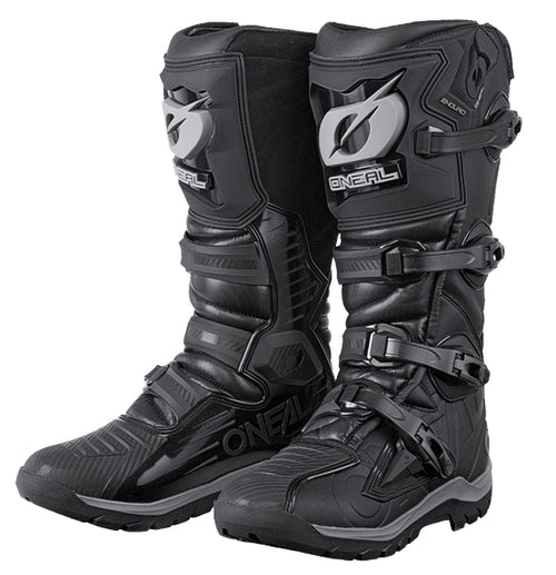 A pair of stylish black and grey O'Neal RMX Enduro Boots from ONEAL includes multiple adjustable buckles and textured soles. These high-cut off-road boots provide protection, support, and prominently showcase brand logos for a striking presence on any motocross adventure.