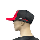 The Honda Kids Cap Red by HRC features a red and black design with a white winged logo and the word "HONDA" on the front. Made from 100% cotton, this cap has a black mesh back and an adjustable snapback strap for perfect sizing.
