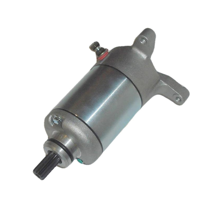 The STARTER MOTOR RICKS MOTORSPORT SUZUKI by RICK'S is a cylindrical electric device with a metallic finish, featuring mounting brackets on both ends and a protruding black shaft. The motor is primarily silver with some weathered or polished texture, and there is a brass screw visible near the center. It comes with a one-year product warranty.