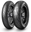 Two black Harley-Davidson motorcycles, sporting robust Metzeler CRUISETEC - Performance Cruiser tires by METZELER, are parked in front of a Harley-Davidson dealership. The image showcases the motorcycles' large rear tires, sleek design, and a hint of urban surroundings with the dealership's branded sign in the background.