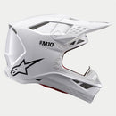 The ALPINESTARS Supertech S-M10 Solid White is a sleek, aerodynamic full-face motocross helmet with ventilation openings and angular contours. A black logo on the side enhances its modern style against a light gray background.