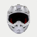 The ALPINESTARS Supertech S-M10 Solid White is a sleek, aerodynamic full-face motocross helmet with ventilation openings and angular contours. A black logo on the side enhances its modern style against a light gray background.