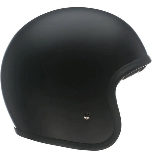 A side view of the Bell CUSTOM 500 Matte Black (NO Studs) motorcycle helmet highlights its smooth, rounded shape and minimalist design. This BELL helmet boasts a low-profile fit and features a small ventilation button near the bottom edge.