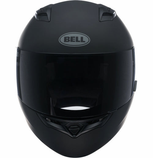 A Bell QUALIFIER Matte Black full-face motorcycle helmet is shown from a side angle, featuring an aerodynamic design with a smooth matte finish and a clear visor. The helmet includes a top vent for airflow, the "Bell" logo on the side, and Multi-Density EPS Liner for enhanced safety.