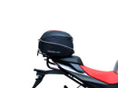 The image shows the EVO-12 Bike-Pack Kit by Ventura for Aprilia Tuono 660, RS660 (21 ->). It includes a black expandable bike pack, an Evo-Rack with Pannier Support, and a generic L-bracket and hardware. Each component is labeled: EVO-12 Pack, Adjustable Pack-Rack, and L-Bracket.