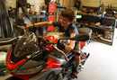 The image shows the EVO-12 Bike-Pack Kit by Ventura for Aprilia Tuono 660, RS660 (21 ->). It includes a black expandable bike pack, an Evo-Rack with Pannier Support, and a generic L-bracket and hardware. Each component is labeled: EVO-12 Pack, Adjustable Pack-Rack, and L-Bracket.