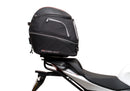 Ventura Aprilia Tuono V4 1100 (21 - >) Bike-Pack Kit shown with labeled images: EVO-12 Pack (soft black bag), EVO-Rack Top-Box Rack (metal bike-mounted rack), and generic L-Bracket plus mounting hardware.