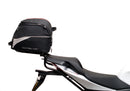 Ventura Aprilia Tuono V4 1100 (21 - >) Bike-Pack Kit shown with labeled images: EVO-12 Pack (soft black bag), EVO-Rack Top-Box Rack (metal bike-mounted rack), and generic L-Bracket plus mounting hardware.