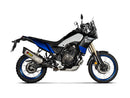 The AKRAPOVIC Slip On Yamaha Tenere 700 is a sleek adventure motorcycle in blue and black, with titanium knobby tires and high exhaust. Shown from a rear three-quarter angle, it highlights its robust build and off-road capabilities, showcasing durability reimagined.