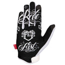 The FIST ANTHONY JEAN FLYING GLOVE is a white motocross glove with black tattoo-style art—an eye with wings and teardrops on the back, detailed finger designs, and a red "FIST" tag by the wrist.