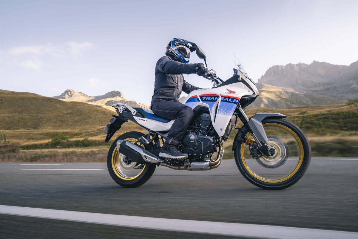 Motorcycle rider on a scenic road with mountains in the background