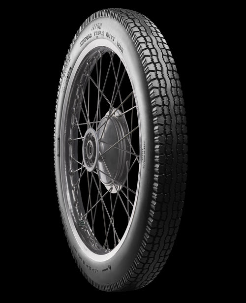 A black Avon Vintage and Classic Tire by Avon Tyres with a shiny silver rim shows a classic tread of thin parallel grooves on its circumference, set against a plain white background.