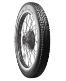 A black Avon Vintage and Classic Tire by Avon Tyres with a shiny silver rim shows a classic tread of thin parallel grooves on its circumference, set against a plain white background.