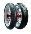 The Avon Storm 3D X-M tires by Avon Tyres are displayed against a black background, featuring high-performance black tread and white rims. Their red hubs with visible spokes emphasize excellent wet grip capabilities, highlighting the tires' superior structure.