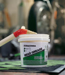 A large white tub of Rabaconda Bead Grease Tire Mounting Lubricant (1kg) is displayed on a black background, showcasing its extra slippery formula and non-toxic, biodegradable properties.