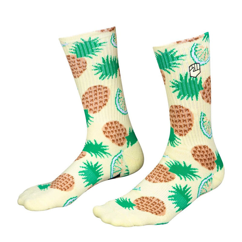 The PINA COLADA SOCK by FIST is a pair of beige crew socks adorned with a lively pattern of green pineapples and brown waffle cones, crafted from ultra-soft cotton.