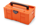 The Husqvarna Battery box L is an orange toolbox with a black handle and gray latch for storing tools, transporting items, or carrying batteries. The Husqvarna logo appears on the front and side. Compatible with the Systainer-Box-System.