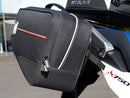 Image displaying the Ventura EVO-12 Bike-Pack Kit for Honda XL 750 Transalp (23->), featuring the EVO-12 pack, Evo-Rack, and an L-bracket with screws. Each labeled component is shown separately against a white background.
