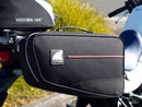 Image displaying the Ventura EVO-12 Bike-Pack Kit for Honda XL 750 Transalp (23->), featuring the EVO-12 pack, Evo-Rack, and an L-bracket with screws. Each labeled component is shown separately against a white background.