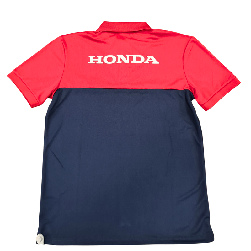 The Honda HRC Polo T-Shirt by HRC features a stylish two-tone design with red on the upper part and sleeves, and navy blue on the lower part. Crafted from 100% polyester, it includes three white buttons on the front and proudly displays "HRC" alongside the Honda logo on the red section, capturing true Honda Team spirit.