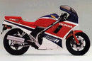 The image presents a Honda VF 1000 RG Bike-Pack Kit by Ventura, featuring a sleek black EVO-12 pack with an orange stripe. It highlights the versatile EVO-Rack mounted on the bike and includes a customizable L-bracket with various components, ideal for any adventure.
