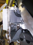 Close-up of the Radiator Frame by Emperor Racing, featuring metal and plastic components with hoses and a side tank. The metal sports an "Emperor Racing" logo.