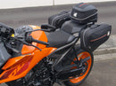 Image showing a Ventura EVO-12 Bike-Pack Kit for KTM 990 Duke (24 - >) with three components: EVO-12 pack bag, Evo-Rack mounted on the motorcycle, and L-brackets with screws. Generic image shown.