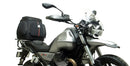 Image featuring the Ventura EVO-12 Bike-Pack Kit: a sleek black EVO-12 pack with an orange stripe, the EVO-Rack securely mounted on a Moto Guzzi 850 V85 TT (19 - >) bike, and an L-Bracket set with screws for excellent pannier support.