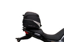 The Ventura EVO-12 Bike-Pack Kit for Moto Guzzi V100, V100S Mandello (22 - >) includes a black EVO-12 pack, a black Evo-Rack or Adjustable Pack-Rack mounted on the motorcycle, and an image of a labeled L-bracket with hardware.