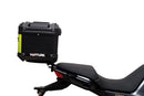 The Ventura EVO-12 Bike-Pack Kit for Moto Guzzi V100, V100S Mandello (22 - >) includes a black EVO-12 pack, a black Evo-Rack or Adjustable Pack-Rack mounted on the motorcycle, and an image of a labeled L-bracket with hardware.