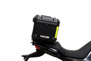 The Ventura EVO-12 Bike-Pack Kit for Moto Guzzi V100, V100S Mandello (22 - >) includes a black EVO-12 pack, a black Evo-Rack or Adjustable Pack-Rack mounted on the motorcycle, and an image of a labeled L-bracket with hardware.