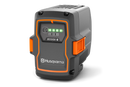 The gray and orange Husqvarna 40-B330X battery pack features four green LED charge indicators. Designed for 36V equipment, this sturdy, rectangular battery is ideal for professional use.