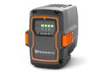 The gray and orange Husqvarna 40-B330X battery pack features four green LED charge indicators. Designed for 36V equipment, this sturdy, rectangular battery is ideal for professional use.