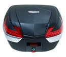 The Ventura Astro Top-box Tour XL is a sleek black and gray motorcycle storage case featuring red reflectors, a white "Ventura-Bike" strip, a rounded top, and a small lock at the bottom.