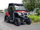 A Honda Pioneer 500 off-road utility vehicle by Ventura is parked on the street, sporting a red and black design, large rugged tires, a protective cage, and robust bull-bar. With a tow-ball for added utility, trees and buildings create the perfect frame for this adventurous machine.