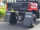 A Honda Pioneer 500 off-road utility vehicle by Ventura is parked on the street, sporting a red and black design, large rugged tires, a protective cage, and robust bull-bar. With a tow-ball for added utility, trees and buildings create the perfect frame for this adventurous machine.
