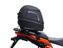 Ventura's EVO-12 Bike-Pack Kit image features a striking black EVO-12 pack with vibrant orange accents, an EVO-Rack gracefully fitted on a Suzuki DL 1050 V-Strom XT bike, and an L-Bracket with screws. The Adjustable Pack-Rack is designed to enhance your biking experience.