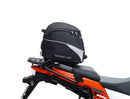 Ventura's EVO-12 Bike-Pack Kit image features a striking black EVO-12 pack with vibrant orange accents, an EVO-Rack gracefully fitted on a Suzuki DL 1050 V-Strom XT bike, and an L-Bracket with screws. The Adjustable Pack-Rack is designed to enhance your biking experience.