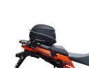 Ventura's EVO-12 Bike-Pack Kit image features a striking black EVO-12 pack with vibrant orange accents, an EVO-Rack gracefully fitted on a Suzuki DL 1050 V-Strom XT bike, and an L-Bracket with screws. The Adjustable Pack-Rack is designed to enhance your biking experience.
