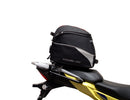 Image showing components of the Ventura EVO-12 Bike-Pack Kit for Suzuki V-Strom 250SX (23->): a black EVO-12 pack, Evo-Rack Adjustable Pack-Rack on a motorcycle, and labeled L-brackets with screws. Each item is individually labeled.