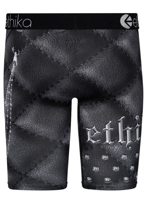 Ethika Chainbossed Staple boxer briefs, crafted by Ethika, showcase a black leather-like pattern and a detailed design of a skull, crossbones, and chain on the right leg. Made with original 4-way stretch fabric, they feature a high-quality waistband prominently displaying the Ethika logo at the center.