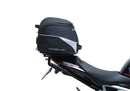 Image showing the Ventura EVO-12 Bike-Pack Kit for Triumph Speed Triple 1200 RS, RR (21 ->), featuring a black EVO-12 Pack tail bag, Evo-Rack Top-Box Rack, and an L-Bracket with screws and mounting hardware.