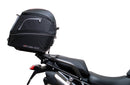 Ventura EVO-12 Bike-Pack Kit for Triumph Tiger 1200GT/Pro/Explorer (22->) includes a black EVO-12 pack, Adjustable Pack-Rack (EVO-RACK) mounted on the bike, and a labeled L-Bracket with screws.