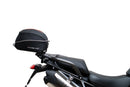 Ventura EVO-12 Bike-Pack Kit for Triumph Tiger 1200GT/Pro/Explorer (22->) includes a black EVO-12 pack, Adjustable Pack-Rack (EVO-RACK) mounted on the bike, and a labeled L-Bracket with screws.