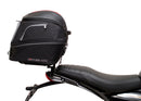 Image showing three components for the Ventura EVO-12 Bike-Pack Kit on a Triumph Scrambler 400X (24->): the EVO-12 pack (black bag), EVO-rack Sport-Rack (metal rack), and L-Bracket with hardware, each labeled with text.