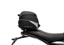 Image showing three components for the Ventura EVO-12 Bike-Pack Kit on a Triumph Scrambler 400X (24->): the EVO-12 pack (black bag), EVO-rack Sport-Rack (metal rack), and L-Bracket with hardware, each labeled with text.