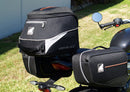 Image showing three components for the Ventura EVO-12 Bike-Pack Kit on a Triumph Scrambler 400X (24->): the EVO-12 pack (black bag), EVO-rack Sport-Rack (metal rack), and L-Bracket with hardware, each labeled with text.