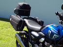 Image showing three components for the Ventura EVO-12 Bike-Pack Kit on a Triumph Scrambler 400X (24->): the EVO-12 pack (black bag), EVO-rack Sport-Rack (metal rack), and L-Bracket with hardware, each labeled with text.