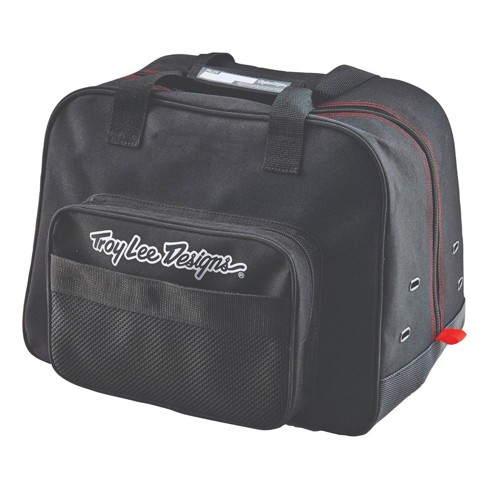 The Troy Lee Designs PREMIUM HELMET BAG BLACK features red stitching, a white front logo, zippered front pocket, mesh detailing, top handles, and silver side grommets for ventilation.